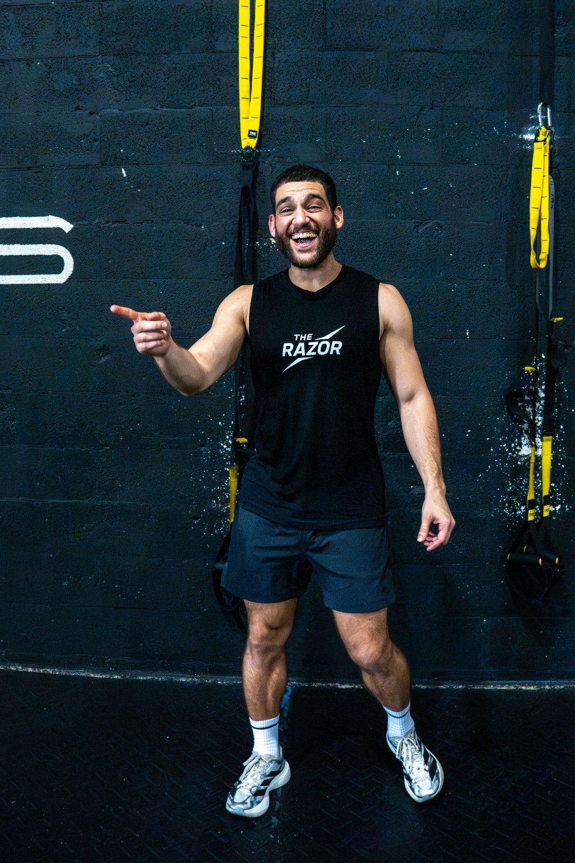 Front view of an athlete wearing The Razor black muscle tank
