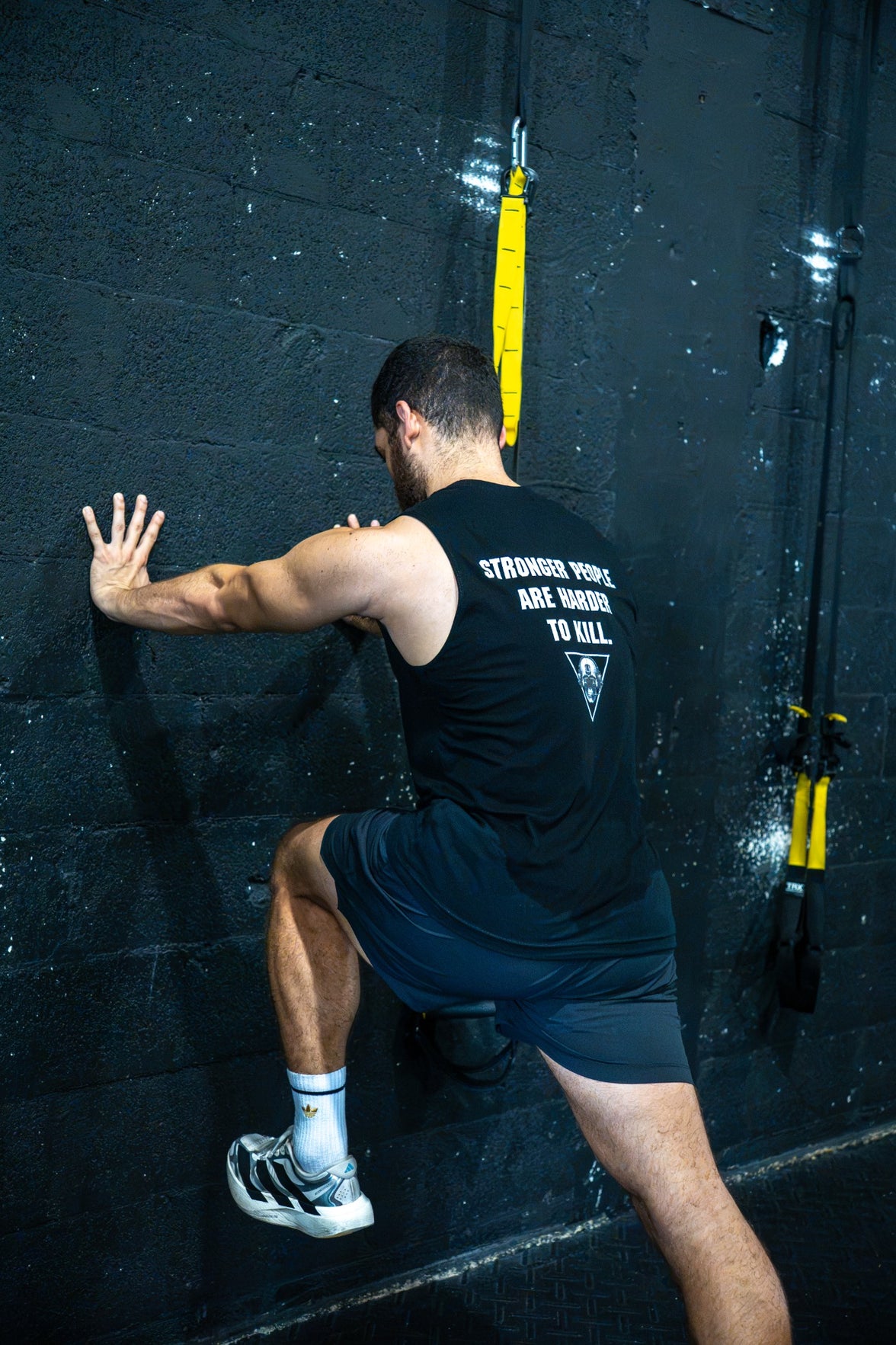 Athlete training in The Razor muscle tank, showing the back design