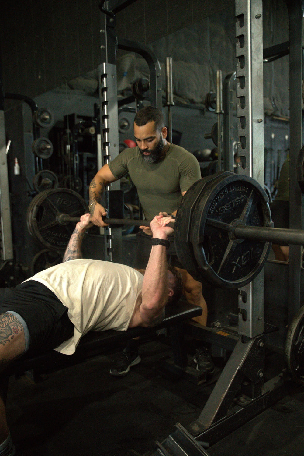 Human performance coach spotting an athlete during a bench press